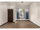 Bright, empty living room featuring wood floors, a window with blue curtains, and a chandelier lighting fixture at 1737 E Marquette Dr, Gilbert, AZ 85234