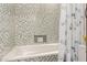 Shower with tiled walls, white tub, and niche for toiletries at 1737 E Marquette Dr, Gilbert, AZ 85234