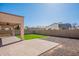 Wide view of the backyard, with a covered patio, green grass, gravel, and a low block wall at 1777 E Dubois Ave, Gilbert, AZ 85298