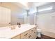 Bright bathroom with double sinks, a large mirror, and a shower/tub combo with white tile surround at 1777 E Dubois Ave, Gilbert, AZ 85298