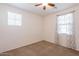 Well-lit carpeted bedroom with a ceiling fan and two windows providing natural light at 1777 E Dubois Ave, Gilbert, AZ 85298