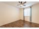 Relaxing bedroom featuring dark hardwood floors, ceiling fan, and a window at 1777 E Dubois Ave, Gilbert, AZ 85298