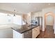 Open-concept kitchen featuring stainless steel appliances, sleek granite island, seamlessly connected to the living room at 1777 E Dubois Ave, Gilbert, AZ 85298