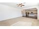 Bright and airy living room with neutral carpet, ceiling fan and views to the kitchen area at 1777 E Dubois Ave, Gilbert, AZ 85298