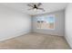 Spacious bedroom features neutral carpet, a ceiling fan, and bright window with shutter-style blinds at 19202 W Jackson St, Buckeye, AZ 85326