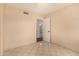 A cozy bedroom with tile floors and a view through an open doorway into the next room at 1925 W Wood Dr, Phoenix, AZ 85029