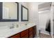 Bathroom with double sink vanity, white countertops, wood cabinets, and a shower-tub combo at 19349 W Oregon Ave, Litchfield Park, AZ 85340