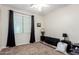 Cozy bedroom with a large window, dark curtains, neutral carpet, and two bedside tables with lamps at 19349 W Oregon Ave, Litchfield Park, AZ 85340