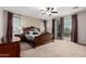 Bedroom with dark wood furniture, ceiling fan, and sliding doors for natural light and outdoor access at 19349 W Oregon Ave, Litchfield Park, AZ 85340