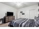 Comfortable bedroom with a striped comforter, dresser with television, white ceiling fan, and closet at 19349 W Oregon Ave, Litchfield Park, AZ 85340