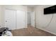 Simple bedroom with closet doors, neutral carpet, and a view into the hallway at 19349 W Oregon Ave, Litchfield Park, AZ 85340