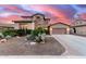 Charming two-story home featuring stone accents, desert landscaping, and a spacious two car driveway at sunset at 19349 W Oregon Ave, Litchfield Park, AZ 85340