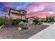 Charming two-story home featuring stone accents, desert landscaping, and a spacious two car driveway at sunset at 19349 W Oregon Ave, Litchfield Park, AZ 85340