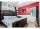 Spacious main bedroom featuring a large decorative bed frame, red accent wall, and plenty of natural light at 19349 W Oregon Ave, Litchfield Park, AZ 85340