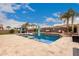 Beautiful backyard pool with a water feature, inviting lounge areas, and tropical landscaping at 19349 W Oregon Ave, Litchfield Park, AZ 85340