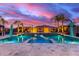 Gorgeous pool at twilight with lounge areas, water features, and lush landscaping for luxurious backyard oasis at 19349 W Oregon Ave, Litchfield Park, AZ 85340