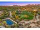 Scenic aerial shot showcasing the lush golf course, tennis courts, and desert landscape under a pink sky at 19550 N Grayhawk Dr # 2038, Scottsdale, AZ 85255