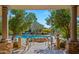 Stunning pool area with a rock feature and view from covered community patio with stone columns at 19550 N Grayhawk Dr # 2038, Scottsdale, AZ 85255