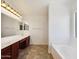 Bathroom featuring double sink vanity with a soaking tub next to a window at 19603 N Toya St, Maricopa, AZ 85138