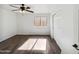 Bright bedroom with wood-look floors, a ceiling fan, window, and a sliding door closet at 19603 N Toya St, Maricopa, AZ 85138