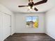 Bright empty room with hardwood floors, a ceiling fan, a bright window view, and white walls at 19603 N Toya St, Maricopa, AZ 85138