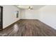 Bright living room with wood-look floors, a ceiling fan and large window at 19603 N Toya St, Maricopa, AZ 85138