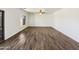 Spacious living room with wood-look floors, a ceiling fan and large window at 19603 N Toya St, Maricopa, AZ 85138