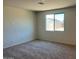 Sunlit bedroom with neutral carpeting and a large window offering neighborhood views at 19889 W Annika Dr, Litchfield Park, AZ 85340