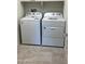 Functional laundry room with modern washer and dryer on neutral tile floor at 19889 W Annika Dr, Litchfield Park, AZ 85340