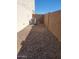 Side yard with gravel, block walls, and an HVAC unit, providing a functional outdoor space at 19889 W Annika Dr, Litchfield Park, AZ 85340