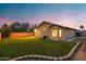 Backyard featuring a lush lawn and the exterior of the home at dusk at 1993 S Spartan St, Gilbert, AZ 85233