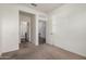 A bedroom featuring neutral carpet, white walls, and doorways, creating a bright and airy atmosphere at 20183 W Monroe St, Buckeye, AZ 85326