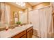 Bathroom featuring a double vanity with decorative towels, a large mirror, and a shower with a curtain at 20742 E Mockingbird Dr, Queen Creek, AZ 85142