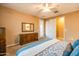 Bright bedroom featuring a ceiling fan, carpet flooring, and a wooden dresser with a large mirror at 20742 E Mockingbird Dr, Queen Creek, AZ 85142