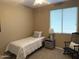 Cozy bedroom featuring a comfortable bed, gray nightstand with lamp, and a rocking chair near a window at 20742 E Mockingbird Dr, Queen Creek, AZ 85142