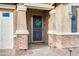 Inviting front door featuring a decorative wreath, secure screen door and brick columns accentuating a welcoming entrance at 20742 E Mockingbird Dr, Queen Creek, AZ 85142