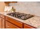 Granite countertops with cooktop and tile backsplash compliment custom cabinets in this gourmet kitchen at 20742 E Mockingbird Dr, Queen Creek, AZ 85142