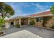 Spacious brick-paved patio, covered area with table and chairs, landscaped garden, and classic architecture at 212 W Interlacken Dr, Phoenix, AZ 85023