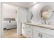 Stylish bathroom with dual sinks, stone countertops, subway tile, and a view of the Primary bedroom at 212 W Interlacken Dr, Phoenix, AZ 85023