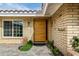 Inviting front entrance showcasing a modern wood door, brick accents, and colorful floral landscaping at 212 W Interlacken Dr, Phoenix, AZ 85023