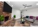 Inviting living room with a cozy brick fireplace, comfortable seating, and modern ceiling fan at 212 W Interlacken Dr, Phoenix, AZ 85023