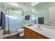 Bright bathroom with a wood vanity, large mirror, and shower with colorful sea life shower curtain at 21520 W Watkins St, Buckeye, AZ 85326