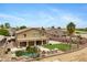Spacious backyard with swimming pool, putting green, BBQ, covered patio, and lush desert landscaping at 21798 N Ingram Ct, Maricopa, AZ 85138