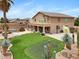 Lush backyard oasis with pool, putting green, basketball court, covered patio, and desert landscaping at 21798 N Ingram Ct, Maricopa, AZ 85138