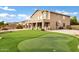 Grassy backyard featuring a putting green and pool area, ideal for outdoor activities at 21798 N Ingram Ct, Maricopa, AZ 85138