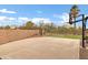 Outdoor half basketball court with mature landscaping and fencing in backyard at 21798 N Ingram Ct, Maricopa, AZ 85138