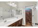 A bright bathroom features double sinks, wood cabinets, large mirror, and a separate water closet at 21798 N Ingram Ct, Maricopa, AZ 85138