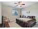 Inviting bedroom with a queen-sized bed, a ceiling fan, and a large window for plenty of natural light at 21798 N Ingram Ct, Maricopa, AZ 85138