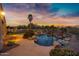 Resort-style pool features rock waterfall and baja shelf, surrounded by lush landscaping, and a built-in BBQ area at 21798 N Ingram Ct, Maricopa, AZ 85138