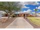 Wide driveway leading to a single-story brick home with mature landscaping and a vibrant front yard at 2230 N 14Th Pl, Phoenix, AZ 85006